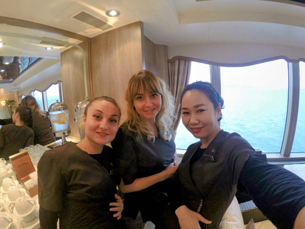 Woman smiling on a ship passing through Japan with colleagues and a friend providing spiritual support.