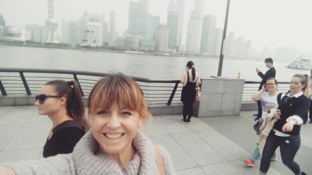 Woman smiling in Shanghai during a trip as a hairstylist on a cruise.