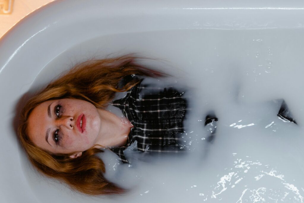 Woman floating in a milky bath, representing product overload and frustration.